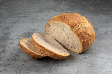 Fresh baked sliced loaf of bread on gray background