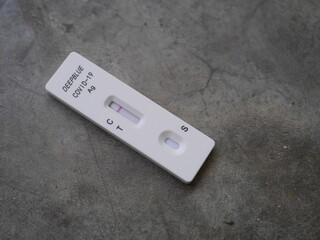 Close-up photo of hand holding Antigen test kit showing results of testing for COVID-19 test result is negative, with alcohol backdrop, ideal for illustrating COVID-19 news.