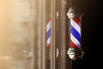 Barber pole spinning at night. International barbershop pole sign. A barber pole calling for people...