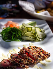 Seared tuna slices with pickled vegetables on a plate