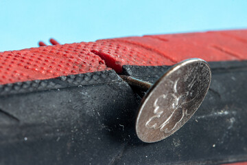 The bicycle tire is damaged by a tack, close up view.