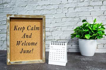 Motivational and inspirational quote on wooden frame with June 2022 calendar.