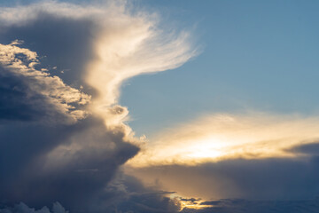 Fototapeta na wymiar A large storm dark cloud of an unusual shape at sunset. Rain is coming.