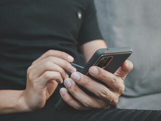 man using smartphone device while sitting on sofa at home. work business, social network.Concept of young people working mobile devices.