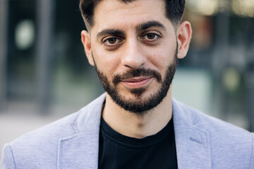 Obraz premium Smiling caucasian young bearded man in formal outfit looking to camera outside on street feel happy businessman portrait business modern manager pretty
