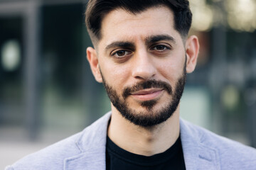 Fototapeta premium Caucasian bearded young man in formal outfit looking to camera outside on street. Feel happy businessman portrait business beautiful modern manager pretty.