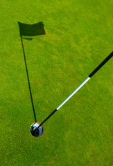 Obraz premium Golf Course Hole With Flagstick Shadow