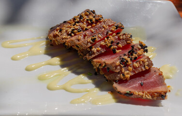 Seared tuna slices with pickled vegetables on a plate