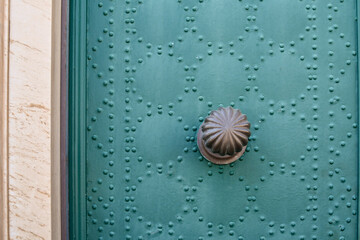 Close-up of a green studded door with a metal knob (materials, backgrounds, textures), Italy