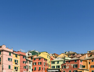 Fototapeta na wymiar Rooftops of the old fishing village with the typical colorful houses against blue sky, Boccadasse, Genoa, Liguria, Italy
