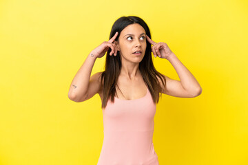 Fototapeta na wymiar Young caucasian woman isolated on yellow background having doubts and thinking