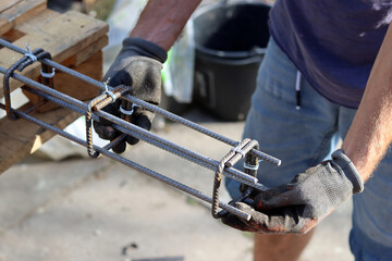 Hand holding reinforcement steel. Professional construction worker.  Close up photo of builder's...