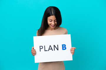 Young woman over isolated background holding a placard with the message PLAN B