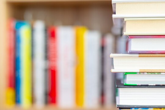 Book stack with blurred bookshelf in the background for business and education concept, school concept