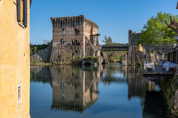 Obraz premium Ruins of Visconti Bridge reflecting into the water at Borghetto sul Mincio, an hamlet of Valleggio sul Mincio, Veneto region, Italy