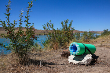 a twisted yoga mat in nature. sports with a view of the water. balance relax       