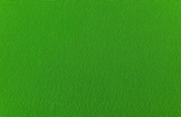 The background is made of green material. Fabric for sewing clothes in a dark shade. Texture