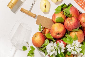 Farm apples, bottle of apple cider, glass and corkscrew on a white background. Eco friendly composition with Summer, Low-alcohol, fruit drink. Fruit wine. Apple product. Soft focus style, flat lay