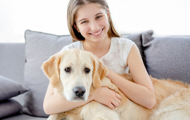 Smiling teenage girl with adorable dog in light room