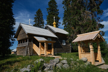 Obraz premium The concept of travel in Russia. One of the most beautiful villages of Karelia Kinerma in summer. The old wooden chapel temple with crosses on roof has been restored or well preserved to our time.