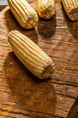 Corn on the cob on rustic wooden background.