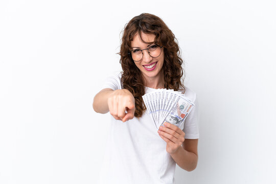 Young woman with curly hair taking a lot of money isolated background on white background pointing front with happy expression