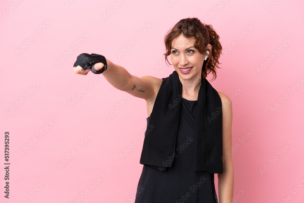 Wall mural Sport sport woman with towel isolated on pink background giving a thumbs up gesture