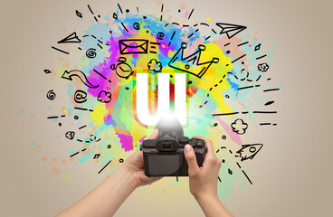 Close-up of a hand holding digital camera with abstract drawing