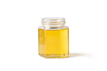 Open glass jar of honey isolated on a white background.