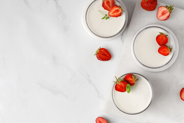 Strawberry panna cotta creamy dessert - panna cotta with strawberry in a glass jars decorated with...