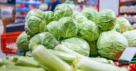 Young cabbage ans zucchini in shop. Green vegetables sold on grocery market. Natural organic veggies at supermarket. Vegetarian healthy nutrition