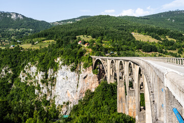 Fototapeta na wymiar Durdevica Tara bridge in Montenegro and beautiful mountain hills in Durmitor national park. Amazing nature view from top