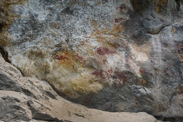 Ancient limestone cliff wall painting of the Mountain Goat. The archaeological site of color paintings of Pratu Pha Valley of Lampang, Thailand.
