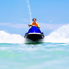 Fototapeta na wymiar Teenager on jet ski. Teen age boy water skiing.