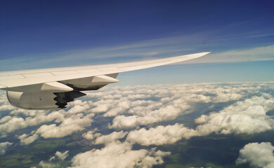 Fototapeta na wymiar beautiful cloudy blue sky and airplane wing, aerial view from airplane window, filter effect