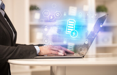 Hands working on laptop with digital icons