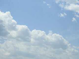 Naklejka na ściany i meble Heavenly blue sky with puffy clouds aloft.