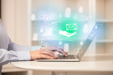 Hands working on laptop with digital icons