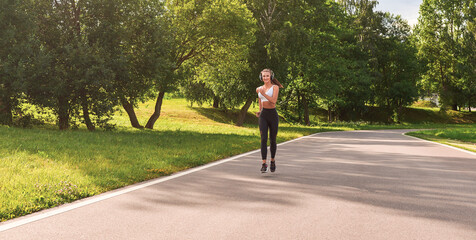 Sports girl jogging in the park. The concept of a healthy lifestyle. Sports Equipment. Fitness style advertisement.