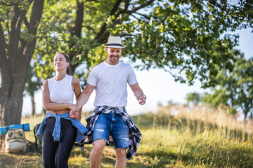 A happy couple climbs the hills in hiking gear.