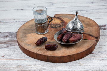 Dates or dates palm fruit (Hurma) is a healthy snack. Him Organic Medjool Ready-to-Eat Dates. Ramadan concept: Dates, zam zam water in copper jugs and glasses and on white table.