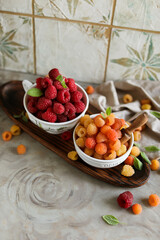 Ripe juicy raspberries in a small bowl. Summer harvest of delicious berries.
