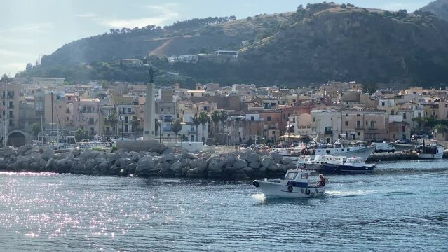 Fisherman boat exiting the harbor in Bagheria, Palermo. - Beautiful seaside town near Palermo, Sicily.