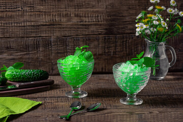 Summer Sicilian dessert granita, frozen juice of fresh cucumber and mint on a wooden background....