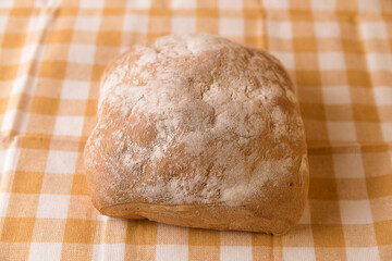 Fresh chabata bread on a yellow towel on a white background