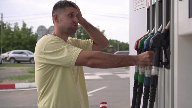 A sad angry man at a gas station is shocked by the increase in car fuel prices. The concept of inflation and rising gasoline prices