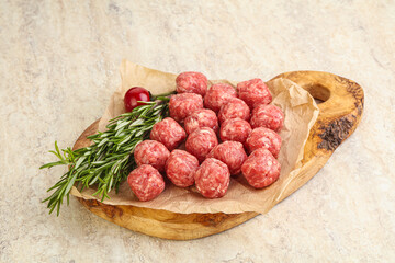 Raw uncooked beef meatballs served rosemary