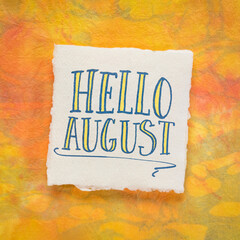 Hello August greeting note  - handwriting on a white handmade paper against colorful marbled background, calendar concept