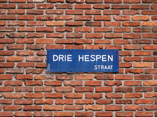 Fototapeta na wymiar Street name in the city of Antwerp in Belgium, translated into English three hams street