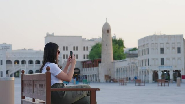  tourist woman taking pictures near Souq Waqif in Doha Qatar
